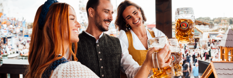 Gäste trinken PAULANER Oktoberfestbier auf dem Balkon des PAULANER Festzelt