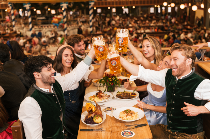 Besucher im Paulaner Festzelt stoßen an: Ein Prosit der Gemütlichkeit!